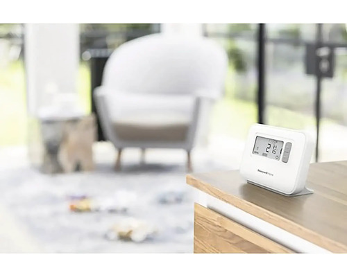 Termostat Honeywell Home na stole v obývacej izbe.
