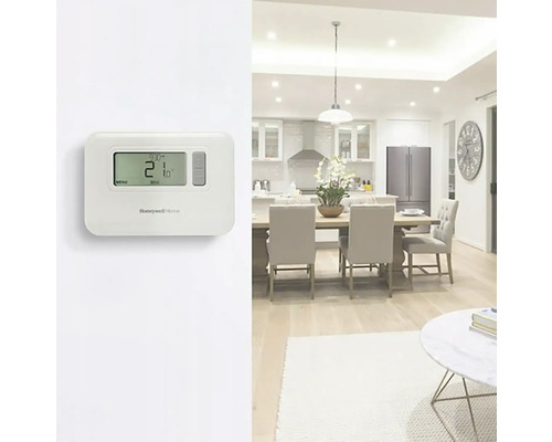 Izbová scéna s elektronickým termostatom na reguláciu teploty a logom Honeywell Home.