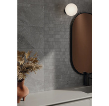 Kúpeľňa so sivými obkladmi stien v kamennom vzhľade, zrkadlom a lampou