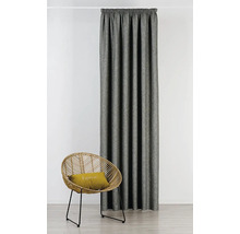 Látkový záves vedľa ratanového kresla s vankúšom