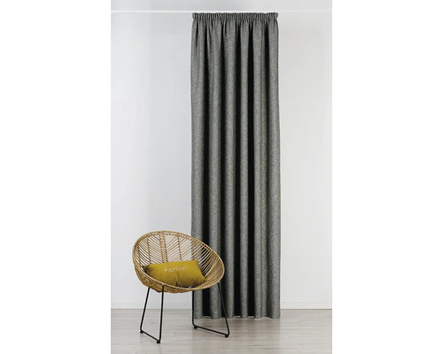 Látkový záves vedľa ratanového kresla s vankúšom