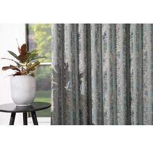 Dekoračné šály so štruktúrovaným vzorom vedľa črepníkovej rastliny na malom stole