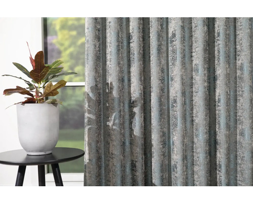 Dekoračné šály so štruktúrovaným vzorom vedľa črepníkovej rastliny na malom stole