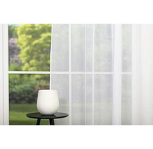 Okno s bielym závesom a váza na príručnom stolíku