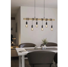 Drevené závesné svietidlo s niekoľkými žiarovkami nad jedálenským stolom.