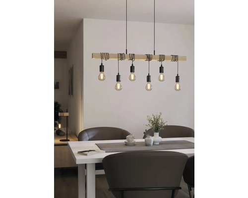 Drevené závesné svietidlo s niekoľkými žiarovkami nad jedálenským stolom.