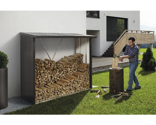 Kovový regál na drevo s drevom a muž rúbajúci drevo v záhrade