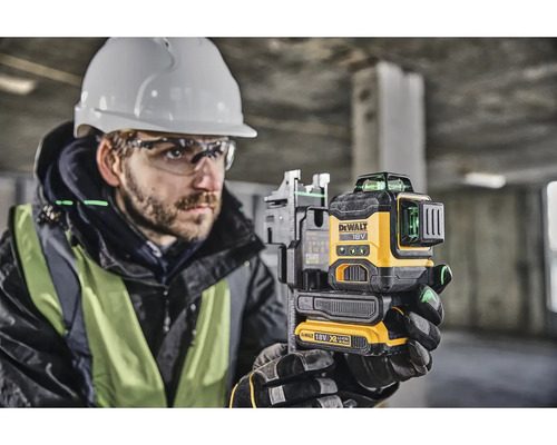 Stavebný robotník s krížovým laserom DeWalt na vyrovnávanie na staveniskách