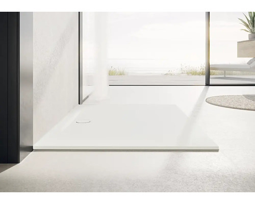 Sprchová vanička v úrovni podlahy vo svetlej kúpeľni.