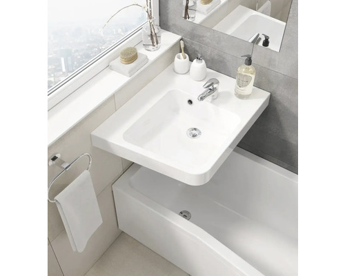 Kúpeľňa s umývadlom, batériou, kruhovým držiakom na uteráky a vaňou.