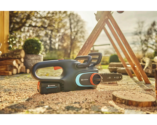 Akumulátorová reťazová píla Gardena s akumulátorom ležiacim na zemi