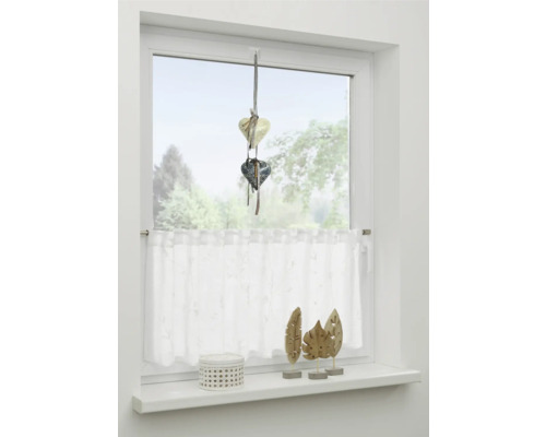 Zdobené okno so srdiečkovým príveskom, záclonou a dekoráciou okenného parapetu