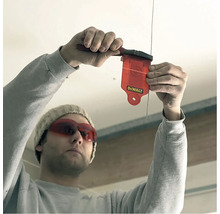 Osoba používa olovnicu na určenie zvislej línie.