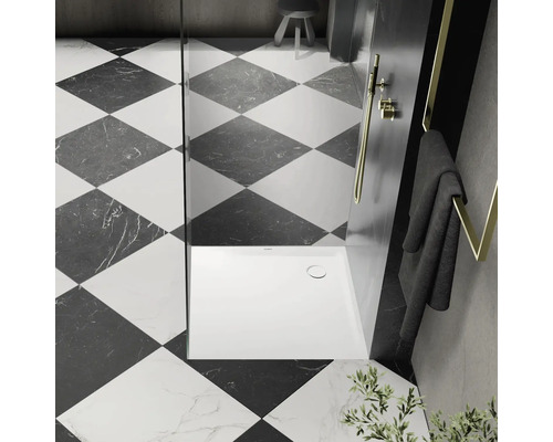 Moderná kúpeľňa so štvorcovým vzorom dlaždíc, sprchou a držiakom na uteráky