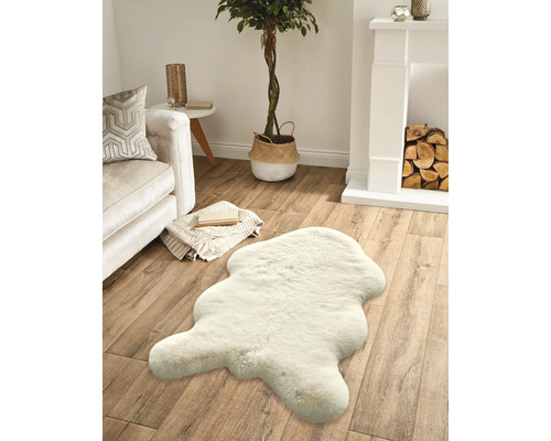 Obývacia izba s pohovkou, krbom, izbovou rastlinou a kobercom vo vzhľade kožušiny