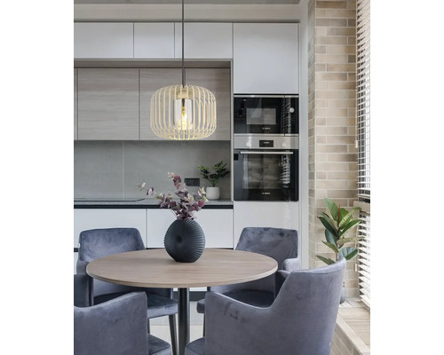 Moderný jedálenský kút s okrúhlym stolom, stoličkami a závesnou lampou v kuchyni