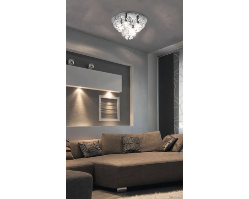Stropné svietidlo s krištáľovými prvkami nad pohovkou v obývacej izbe