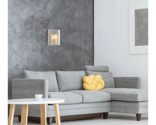 Obývacia izba so sivou pohovkou, príručným stolíkom a nástenným svietidlom