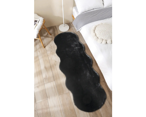 Čierny koberec v spálni na drevenej podlahe