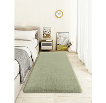 Spálňa s posteľou, nočným stolíkom, nástennými hodinami a obdĺžnikovým kobercom