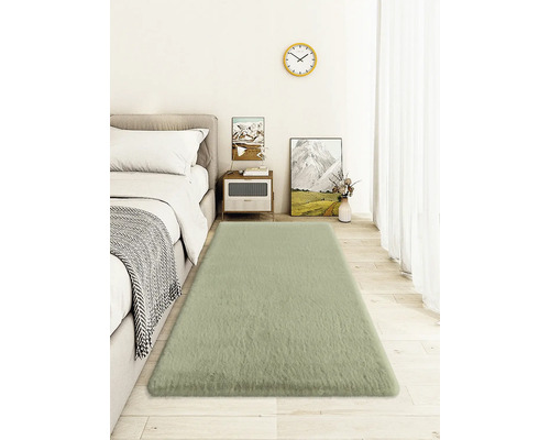 Spálňa s posteľou, nočným stolíkom, nástennými hodinami a obdĺžnikovým kobercom