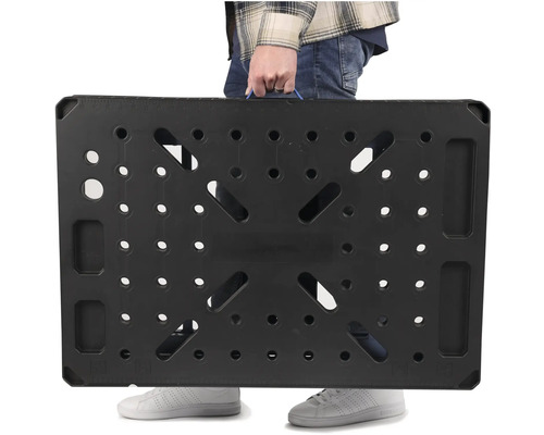 Osoba nesie čierny pracovný stôl s rukoväťou