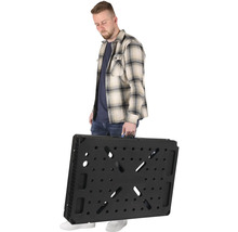 Muž nesie zložený pracovný stôl