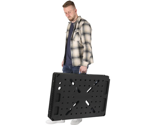 Muž nesie zložený pracovný stôl