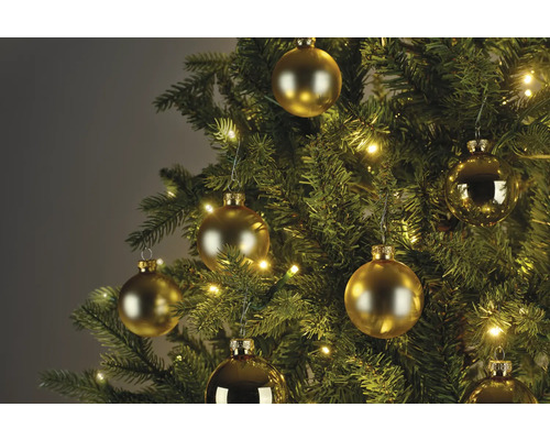 Detailný záber vianočného stromčeka so zlatými guľami a svetlami