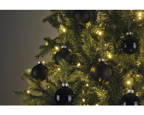 Detail vianočného stromčeka s čiernymi ozdobami a svetelnou reťazou