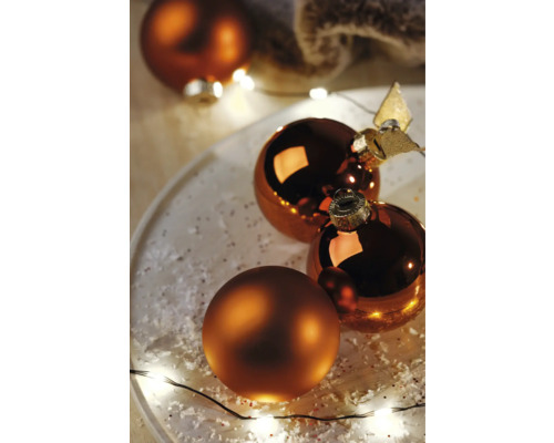 Dekoratívne vianočné gule so svetelnou reťazou na tanieri