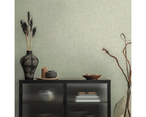 Interiérová scéna s čiernou komodou so sklenenou prednou stranou pred štruktúrovanou tapetou