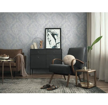 Obývacia izba s tapetou so vzorom, kreslom a komodou