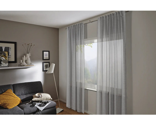 Obývacia izba so záclonami, pohovkou a stojacou lampou pre útulnú atmosféru