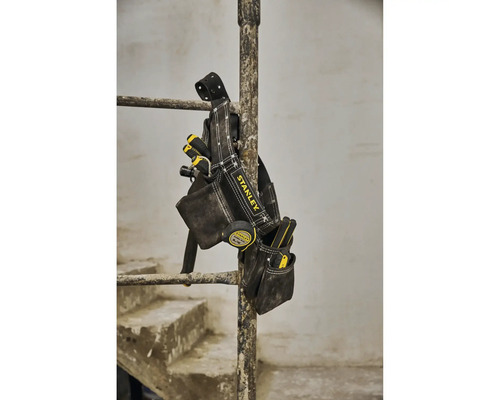 Taška na náradie Stanley s rôznym náradím visí na tyči.