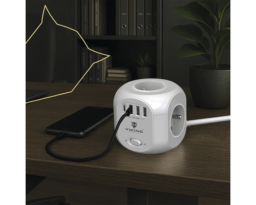 Zásuvková kocka s USB portami a pripojeným mobilným telefónom na stole