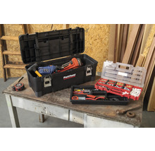 Otvorený kufor na náradie s náradím a sortimentom drobných dielov na stole.