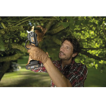 Muž strihá konár akumulátorovými nožnicami na konáre Worx Nitro.