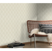 Obývacia izba s geometrickou tapetou, stoličkou a dekoratívnymi prvkami pre štýlové prostredie.