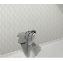 Svetlá stena s geometrickým vzorom a stolička s dekou