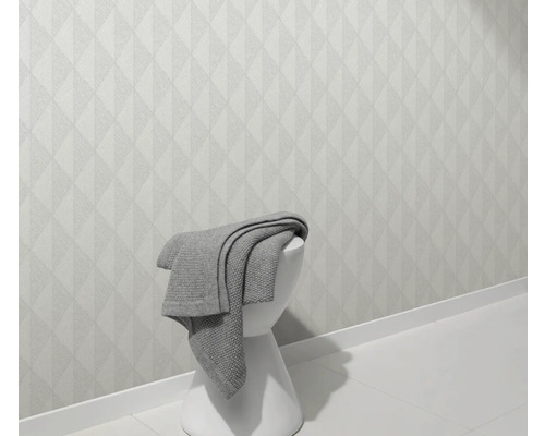 Svetlá stena s geometrickým vzorom a stolička s dekou