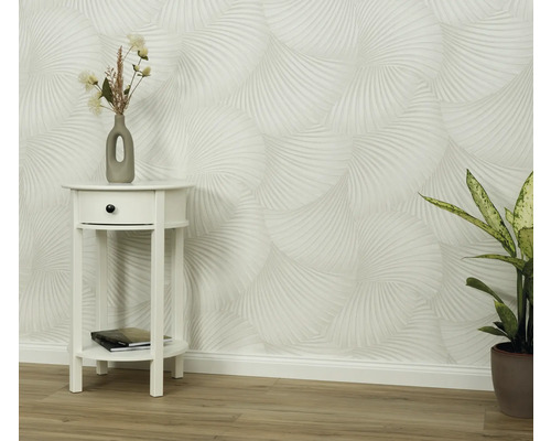 Scéna so vzorovanou tapetou, nočným stolíkom a izbovou rastlinou.