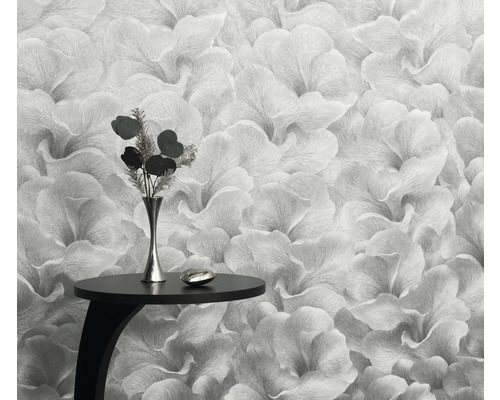 Detailný záber kvetinovej tapety s malým stolom a vázou