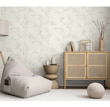 Svetlá obývacia izba s tapetou s motívom listov, sedacím vakom, komodou a príručným stolíkom