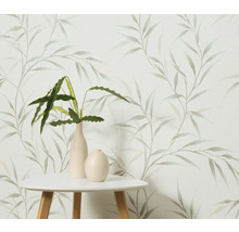 Dekoratívna tapeta s motívom listov, kombinovaná so stolom a izbovými rastlinami vo vázach.