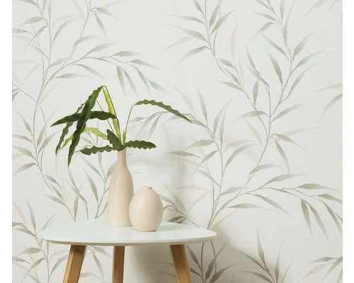 Dekoratívna tapeta s motívom listov, kombinovaná so stolom a izbovými rastlinami vo vázach.