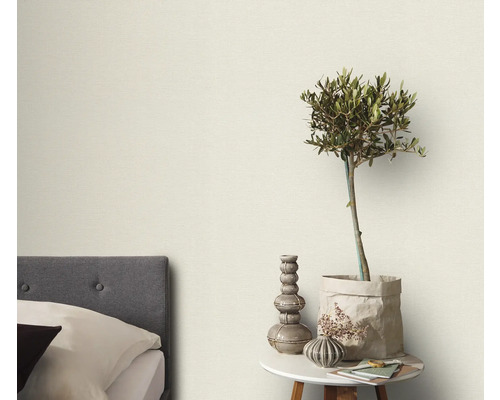 Spálňa s posteľou, odkladacím stolíkom a dekoratívnymi prvkami, ako je rastlina a vázy