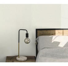 Spálňová scéna s nočnou lampou na drevenom stolíku vedľa postele