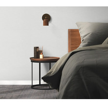 Spálňa s posteľou, nočným stolíkom, lampou a rozprašovačom vôní