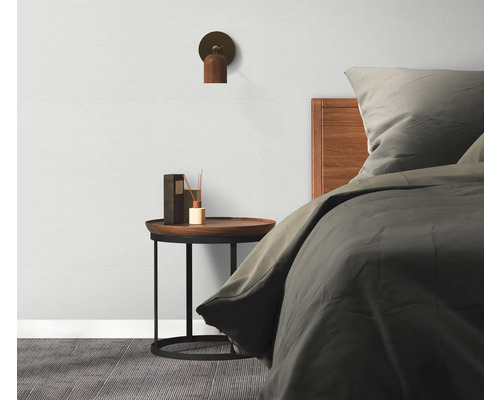 Spálňa s posteľou, nočným stolíkom, lampou a rozprašovačom vôní